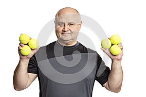 Smiling adult bald man in sportswear with tennis balls in his hands. Isolated on a white background