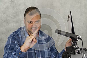 Smiling adult blogger making online stream for social media, gesturing, talking and using  camera