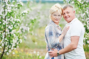 Smiling adult couple at blossom apple orchard