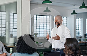 Smiling African American businessman having a meeting with his team