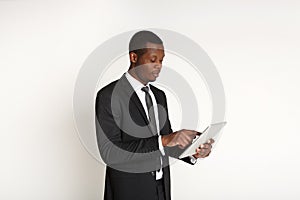 Smiling african american businessman using tablet.