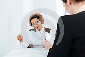 Smiling african american businesswoman having job interview and filling application