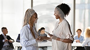 Smiling African American businesswoman hr manager shaking new employee hand
