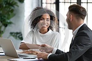 Smiling African American businesswoman shaking client hand at meeting photo