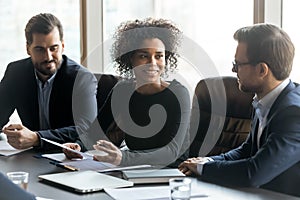 Smiling African American businesswoman speaking at corporate meeting