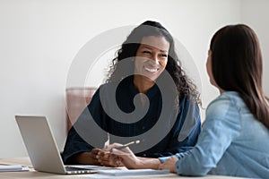 Smiling African American businesswoman talking to colleague at meeting