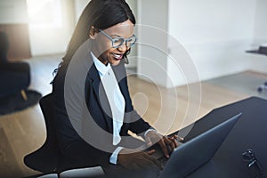Smiling African American businesswoman working in her office