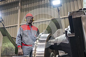 Smiling African American CNC Machine Operator Monitoring The Train Wheel Manufacturing Process In A Train Factory