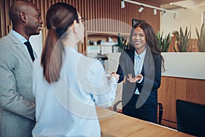 Smiling African American concierge talking with guests during ch photo