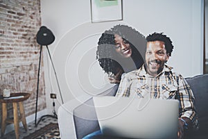 Smiling african american couple relaxing together on the couch.Young black man and his girlfriend using laptop at home