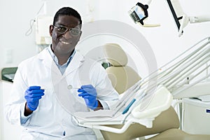 Smiling african american dentist standing in dental office