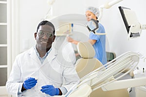 Smiling african american dentist standing in dental office