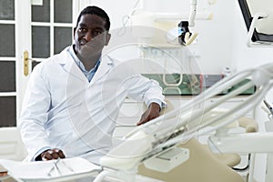 Smiling african american dentist standing in dental office