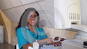 Smiling african american doctor working on ultrasound device