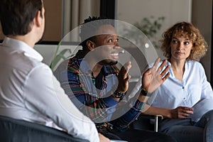 Smiling African American employee speaking at corporate meeting in office