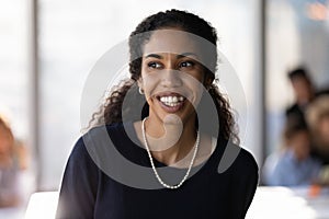Smiling African American female employee look in distance