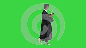 Smiling African American female graduate making selfie with diploma on a Green Screen, Chroma Key.