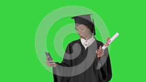 Smiling African American female graduate making selfie with diploma on a Green Screen, Chroma Key.