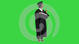 Smiling African American female student in graduation robe posing with diploma on a Green Screen, Chroma Key.