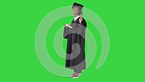 Smiling African American female student in graduation robe posing with diploma on a Green Screen, Chroma Key.