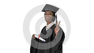 Smiling African American female student in graduation robe posing with diploma on white background.