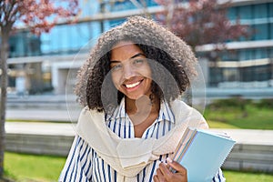 Smiling African American girl student in university outdoor campus, portrait.