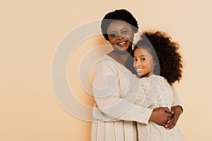 smiling african american grandmother hugging granddaughter