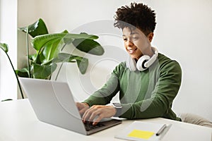 Smiling african american guy independent contractor typing on computer