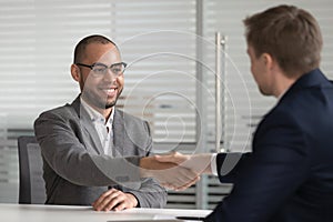 Smiling african american job applicant handshake hr employer get hired