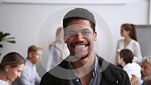 Smiling african american male employee posing at team office meeting