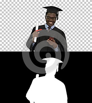 Smiling african american male student in graduation robe with di