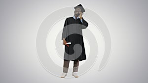 Smiling african american male student in graduation robe talking