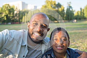 Smiling African American man and boy taking photo together