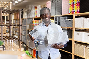 Smiling african american man choosing storage box at store