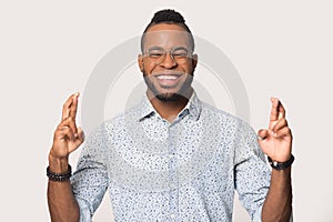 Smiling African American man crossing fingers wishing good luck