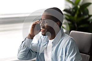 Smiling african American man having pleasant smartphone call