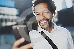 Smiling African American man in headphone making video call via mobile phone in hand.Concept of guy using Internet