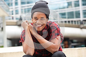 Smiling african american man sitting outside in city