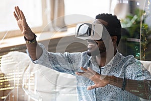 Smiling African American man in VR glasses enjoying augmented reality photo