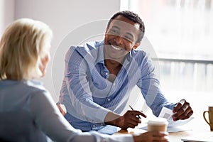 Smiling african american manager talking with client at business meeting photo