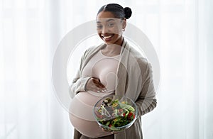 Smiling african american pregnant woman showing her lunch