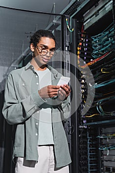 smiling african american programmer using mobile