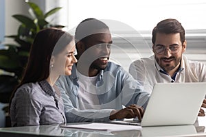 Smiling african american team leader working on computer with colleagues.