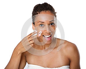 Smiling african american woman applying lotion on skin