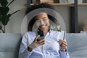 Smiling African American woman buy online on cellphone