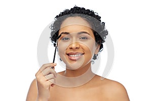 smiling african american woman with mascara brush