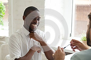 Smiling African American laughing while talking to colleague photo