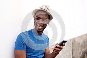 Smiling african american young man holding cellphone photo