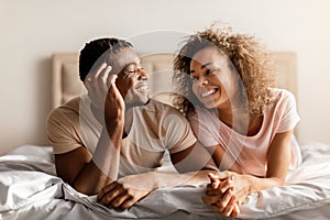 Smiling African American Young Spouses Lying Together In Comfortable Bed
