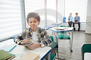 Smiling African Boy using Tablet in School Classroom